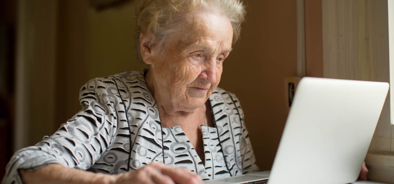 elderly woman using Mac laptop